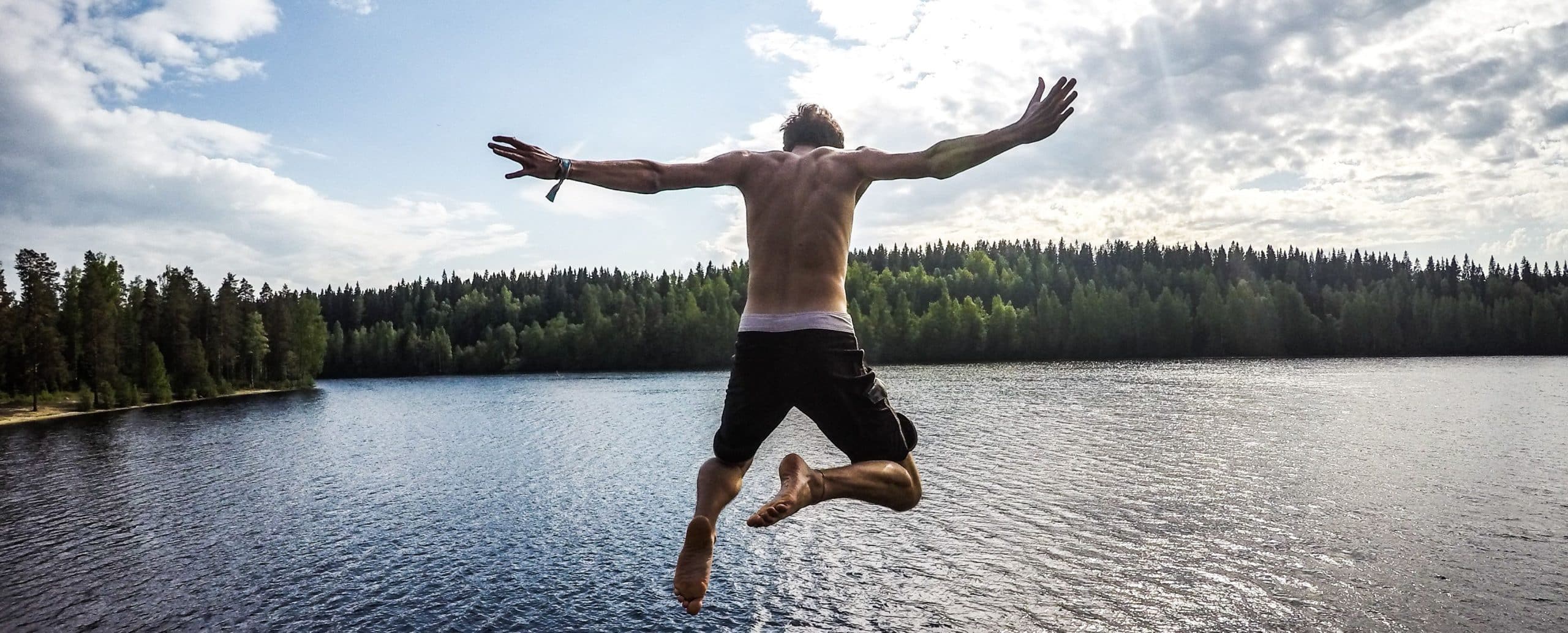 man-jumping-from-a-pier-into-water